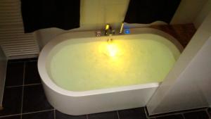 卡德赞德Luxe kamer Cadzand的浴室内设有带蜡烛的浴缸。