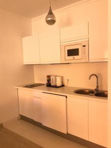 蒙特卡罗Monaco Studio "907"的厨房配有白色橱柜和微波炉