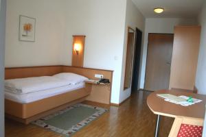 霍恩埃姆斯洛伦茨酒店 的一间小卧室,配有一张床和一张桌子