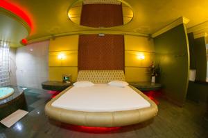 福塔莱萨Shanadu Motel (Adults Only)的一间卧室设有一张大床和一个浴缸