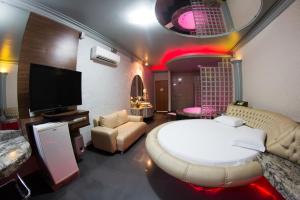 福塔莱萨Shanadu Motel (Adults Only)的卧室配有一张白色大床和电视。