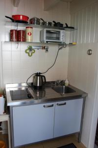 赫伊斯代嫩Zomerhuisje op Huisduinen的一间带水槽和微波炉的小厨房