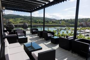 普伦西亚Hotel Boutique Bahía de Plentzia的一个带桌椅的河景庭院