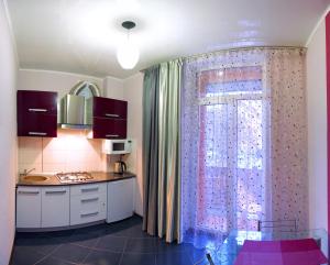 尼古拉耶夫Apartment Dekabrystiv的厨房设有窗户、窗帘和水槽