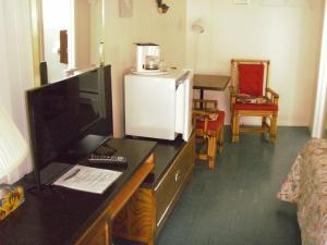 Lansdowne御千岛卡普里柯汽车旅馆的一间带电视的书桌的房间和一间带桌子的房间