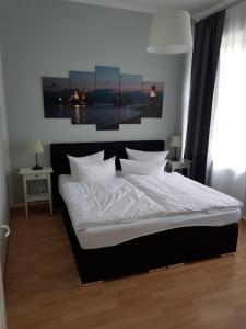 罗斯托克费舍尔昂旅馆的卧室内的一张带白色床单和枕头的床