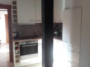 基尔Apartment-unter-Reet的厨房配有白色橱柜和炉灶烤箱。