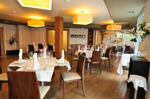 格罗韦奥格罗韦高级Spa3号酒店的一间设有白色桌椅和黄色灯光的餐厅