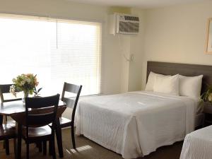 蒙托克波浪酒店 - 蒙托克的卧室配有一张床和一张桌子及椅子