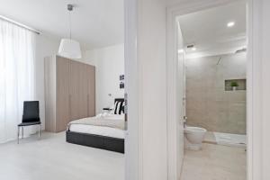 罗马白色特米尼公寓的一间白色卧室,配有床和一间浴室