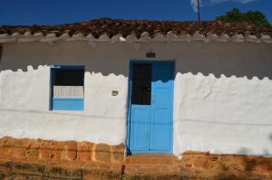 巴里查拉Albahaca Hospedaje Tienda的白色的房子,有蓝色的门和窗户