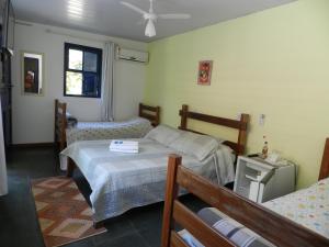 伊塔蒂亚亚Pousada Ypê Amarelo的一间卧室设有两张床和窗户。
