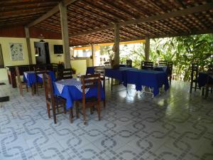 伊塔蒂亚亚Pousada Ypê Amarelo的一间配备有蓝色桌椅的用餐室