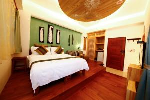 礁溪汤巢莎瓦迪卡民宿的卧室配有白色的床和绿色的墙壁