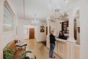 吉日茨科Hotel Cesarski - Kaiserhof的两名妇女站在房间里柜台