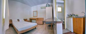 米蒂利尼Pefka Rooms的一间带床的小卧室和一间厨房