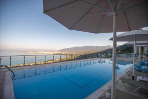 卡拉马塔丽城酒店的一个带遮阳伞的游泳池,享有水景