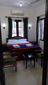 科钦Elim Homestay Fort Kochi的一间卧室配有一张带绿色窗帘的大床