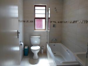 约翰内斯堡梅尔维尔塔楼旅馆的浴室配有卫生间、浴缸和水槽。