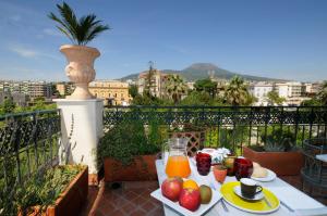 埃尔科拉诺巴蒂斯塔别墅酒店 的阳台上的桌子上摆放着水果和果汁