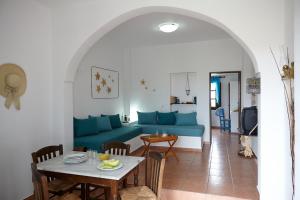 卡马利安娜传统公寓酒店的客厅配有蓝色的沙发和桌子