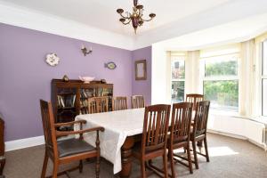 戈尔韦Boutique Guest House的一间拥有紫色墙壁和桌椅的用餐室