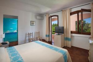 切尔沃港卡普里乔利酒店的一间卧室设有一张床、一台电视和窗户。