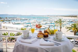 埃斯塔蒂特利阿里潜水酒店的一张桌子,上面摆放着食物和饮料,享有海港的景色
