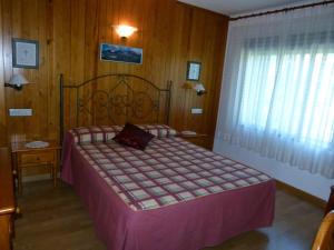 托尔拉Hotel Bellavista Ordesa的一间卧室配有一张带紫色棉被的床