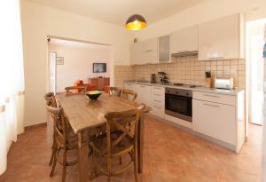 赫尔采格诺维Olive Tree Villa的厨房配有木桌和一些椅子