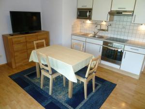 海因岑贝格索嫩特劳姆公寓的厨房配有桌椅和电视。