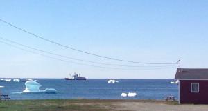 博纳维斯塔Oceanside Cabins的水中的冰山,远处有一艘船
