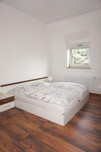 杜塞尔多夫阿图斯酒店的铺有木地板的客房内的一张白色床