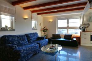 基彭海姆Gesindehaus Charis的客厅配有蓝色的沙发和桌子