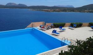 罗通多港Ladumar Sardinia的蓝色的游泳池,享有水景