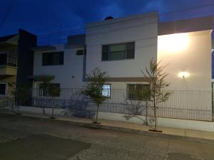 OcotlánCasa RyS Hotel的街道旁的白色建筑,有栅栏