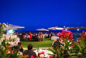 泰拉奇纳托乐德索雷酒店的一群人坐在晚上聚会的桌子旁