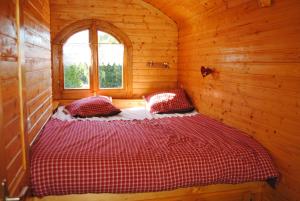 Lamothe-Capdevillela Roulotte du Cos的小木屋内一间卧室,配有一张床