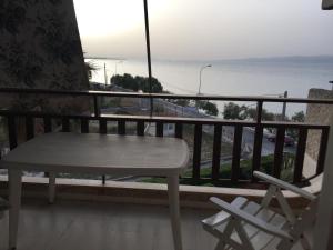 卡拉莫斯Vlastos Apartment的阳台配有一张桌子和两把椅子,享有海景