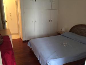 卡拉莫斯Vlastos Apartment的一间卧室配有一张床和白色橱柜