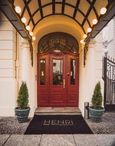 柏林柏林选帝侯大道亨利酒店的两棵盆栽植物的楼房的红色门