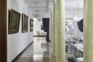 阿巴诺泰尔梅特里雅斯特和维多利亚大酒店的墙上挂有柱子和画作的走廊