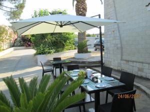 奥斯图尼热带酒店的庭院设有两张桌子和一把伞