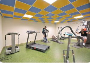 Witry-lès-Reims普里姆兰斯酒店的健身房,有几个人使用跑步机锻炼