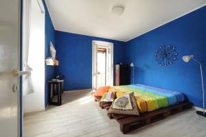 PapignoCasetta di Cleo的一间卧室设有蓝色的墙壁和一张带长凳的床