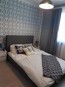斯蒂格纳Pokoje Morska Syrenka的卧室配有一张带灰色白色墙壁的床