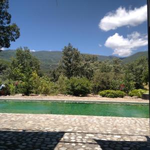 波亚莱斯－德尔奥约Hotel Rural Casa Alfayales-Only Adults的一座绿色的海水游泳池,背景是群山