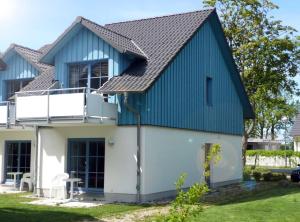 PutgartenFerienwohnung Finja in Putgarten, Kap Arkona Rügen的蓝色屋顶的房子
