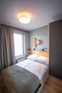 尤斯托尼莫斯基Apartamenty Sea Stars的一间卧室设有两张床和大窗户