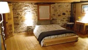 Prata CamportaccioB&B Sasso Bianco的一间卧室设有一张床和石墙